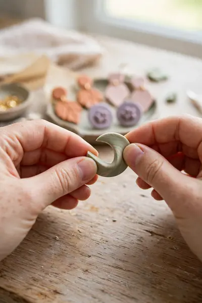 Hands bend-testing a cooled polymer clay earring