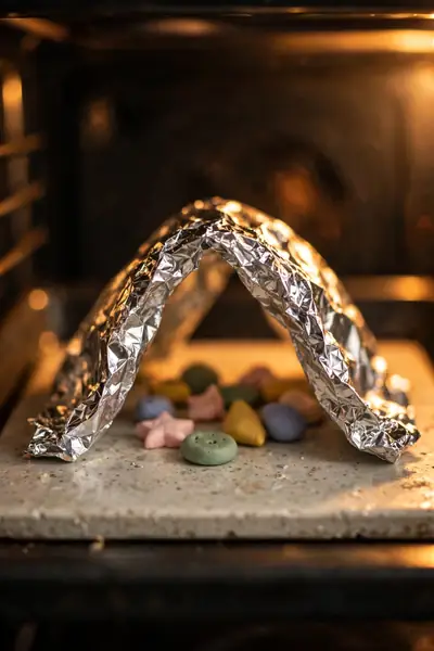 Polymer clay pieces tented with foil in oven