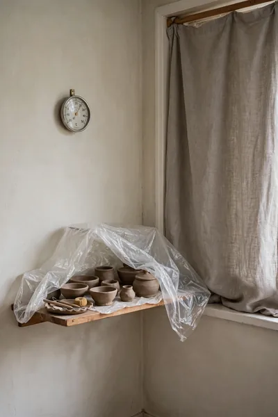 clay pieces drying on a shelf in a quiet corner
