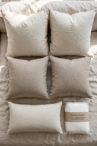 Throw pillows in graduated sizes with a feather insert on a sofa