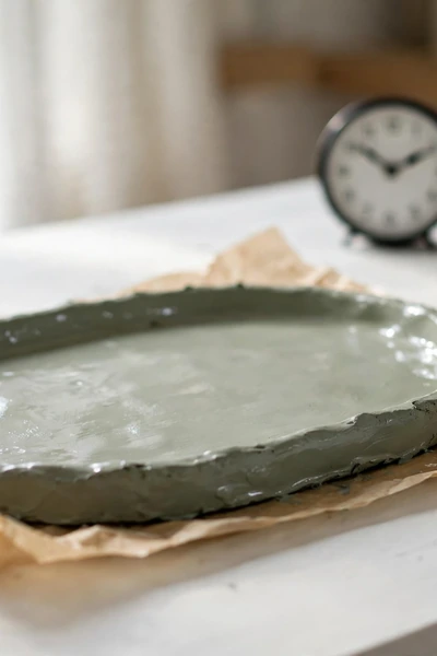 Sealed clay tray drying on parchment