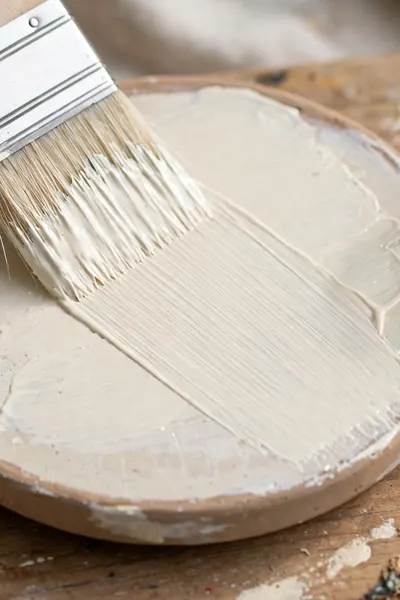 thin cream paint coat brushed onto a dish