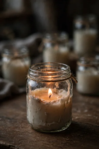 Lit candle with a weak small flame in a glass jar